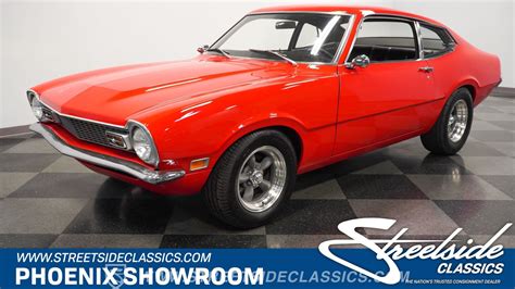 A customized 1973 Ford Maverick with modern wheels and a lowered stance, showcasing performance modifications