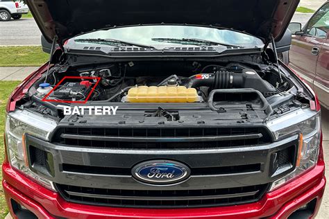 A mechanic is inspecting and replacing the Ford F150 battery